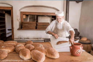 Baker buttering and wrapping bread at Old Salem NC
